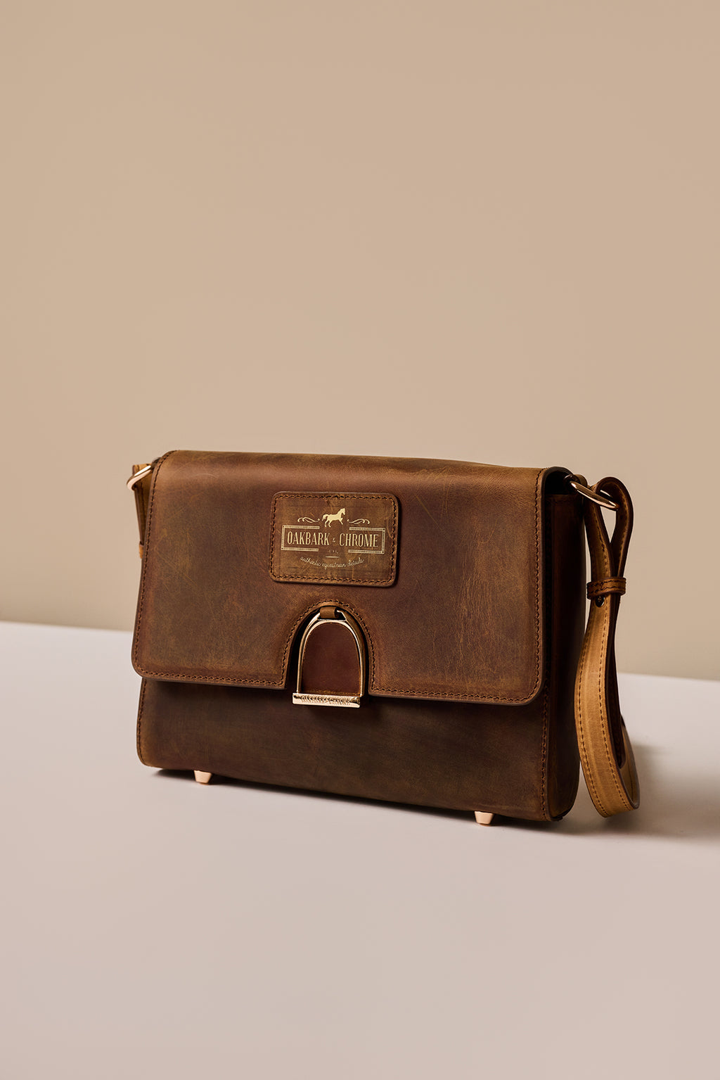 Brown leather bag with a visible brand logo on a beige background