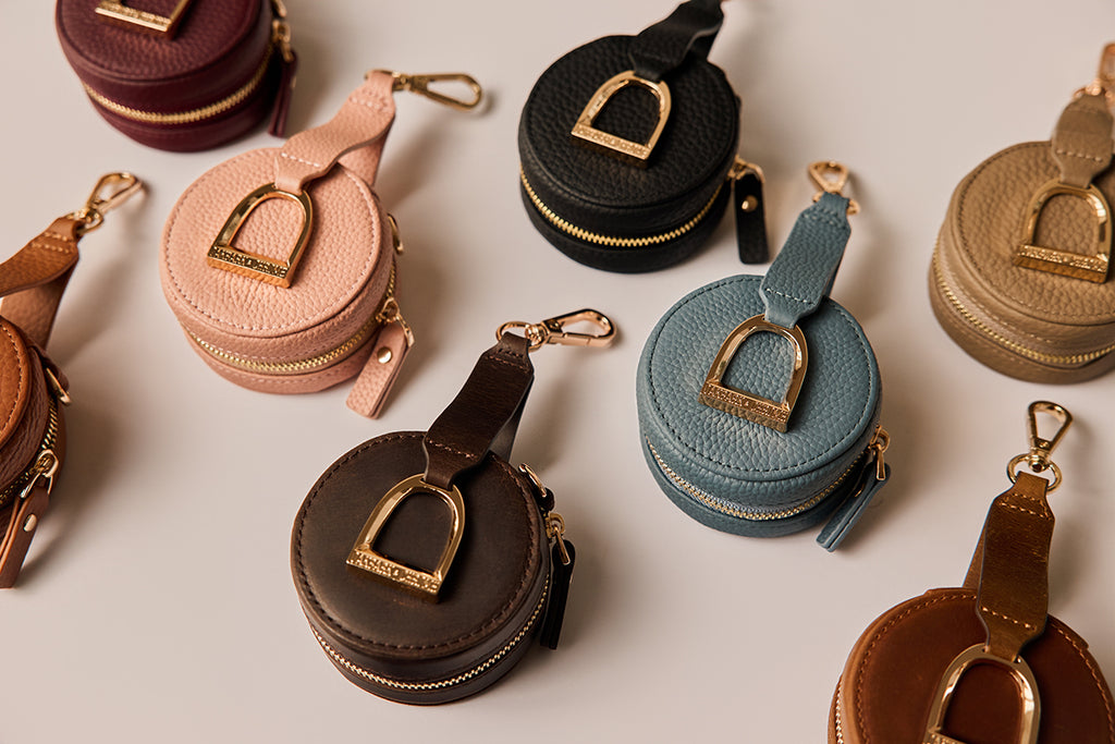 Collection of round leather coin purses in various colors on a light background