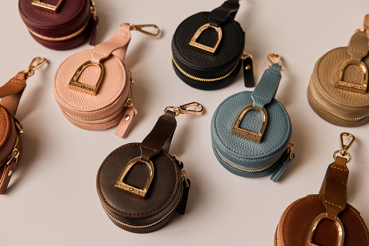 Collection of round leather coin purses in various colors on a light background