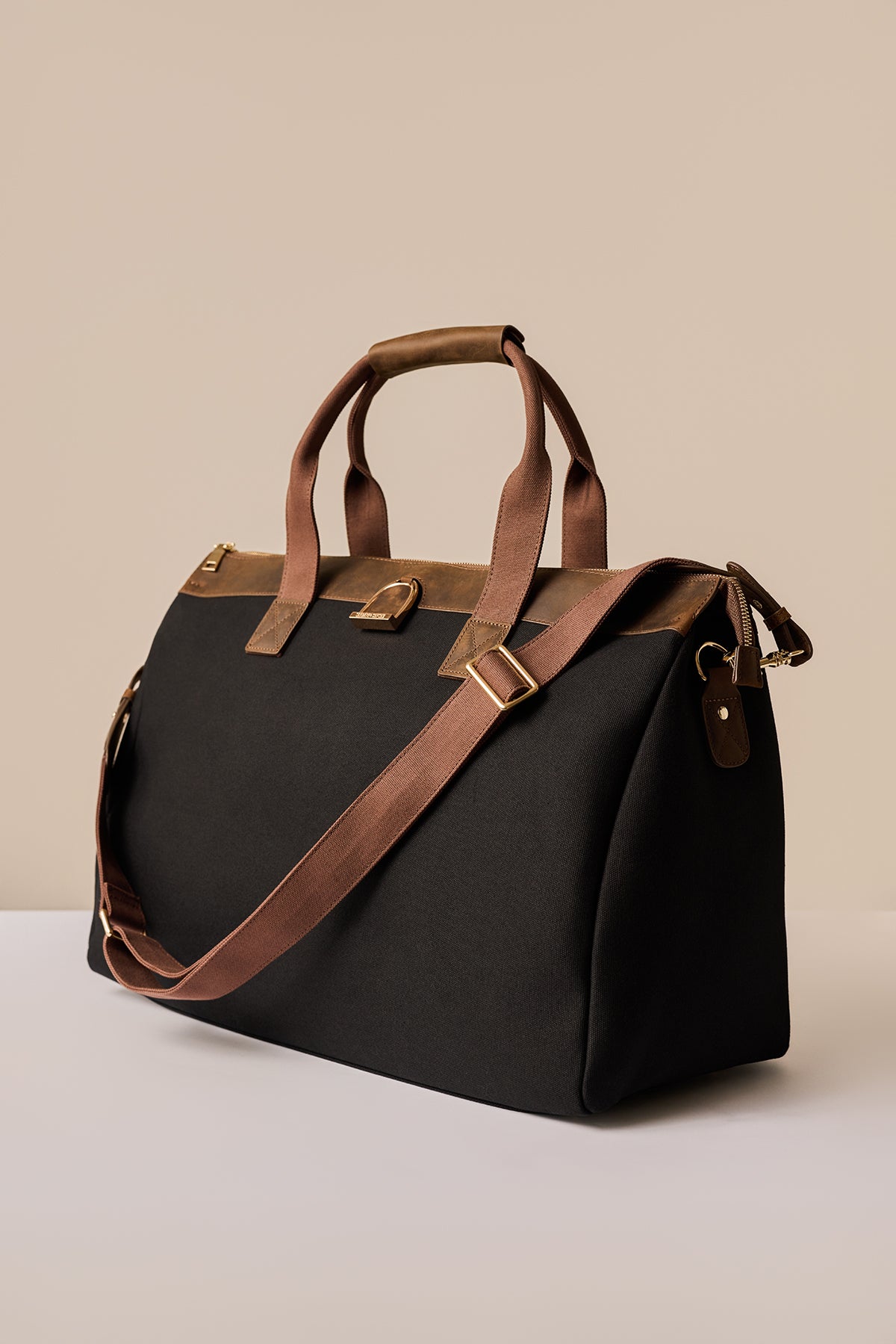 Black bag with brown straps on a beige background