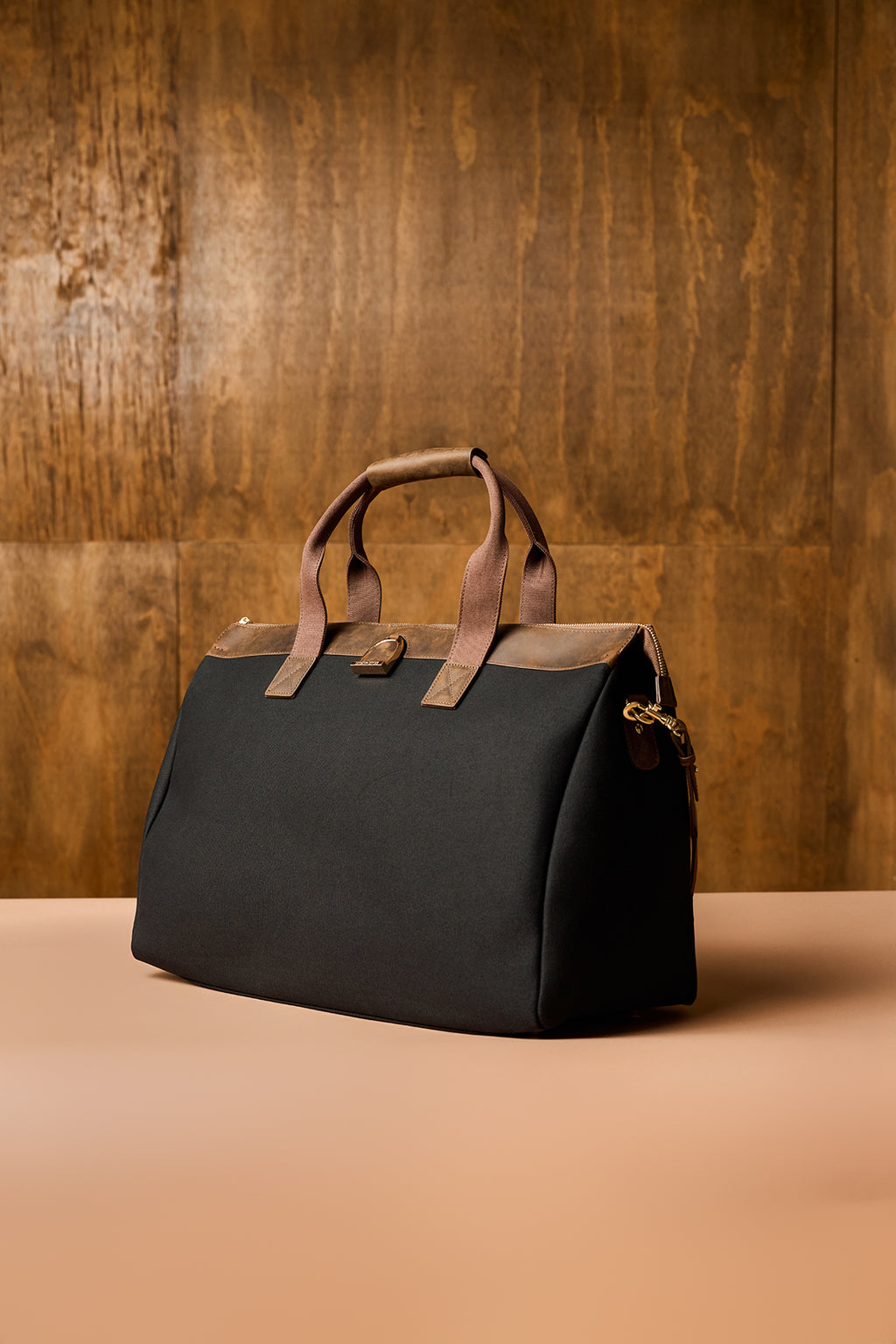 Black bag with brown handles on a wooden background