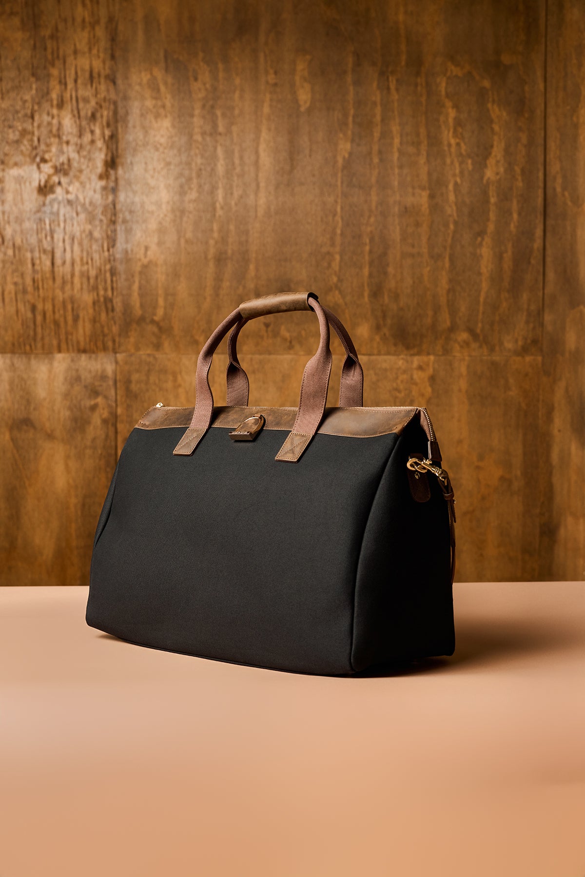 Black bag with brown handles on a wooden background