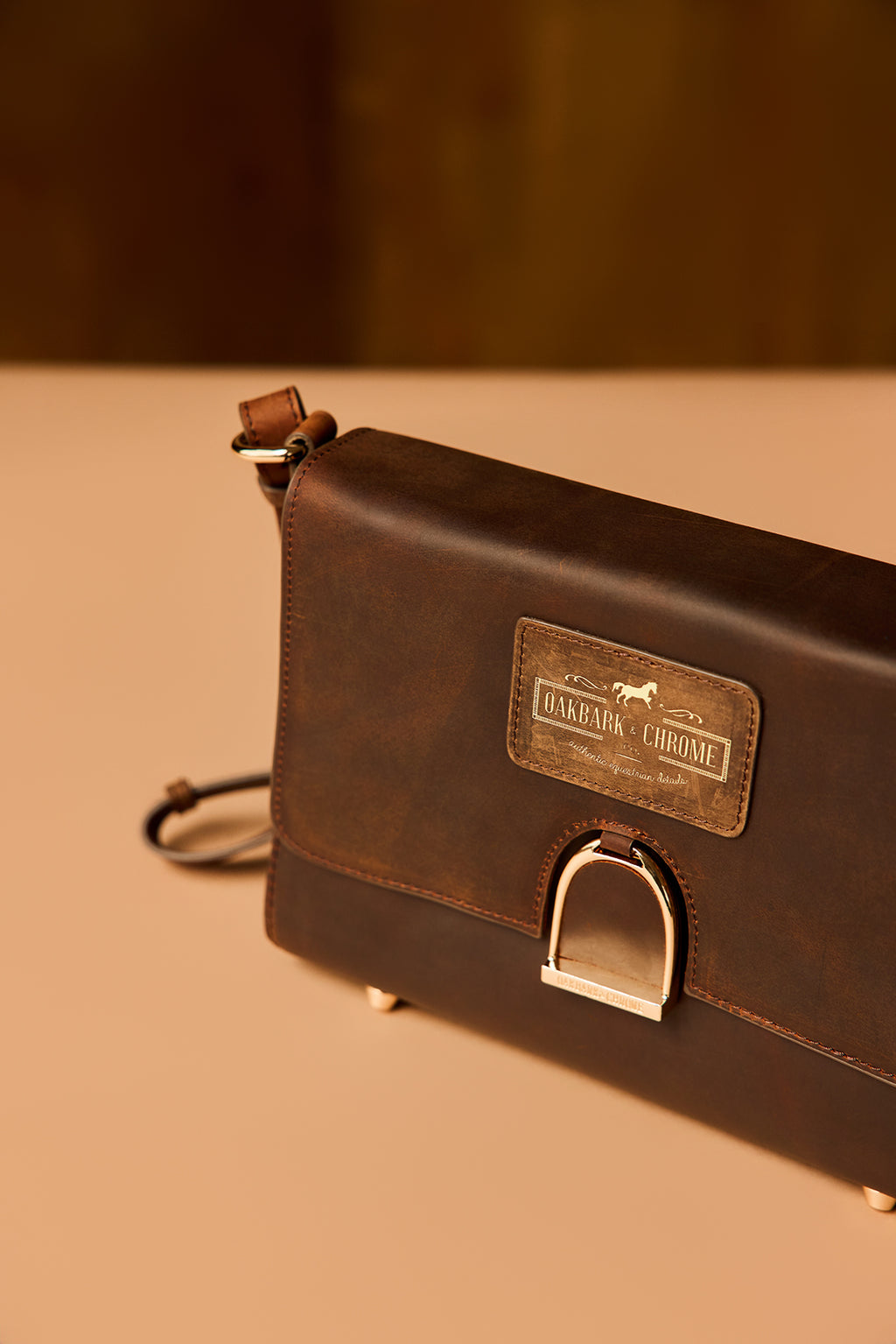 Brown leather bag with a visible brand label on a beige background