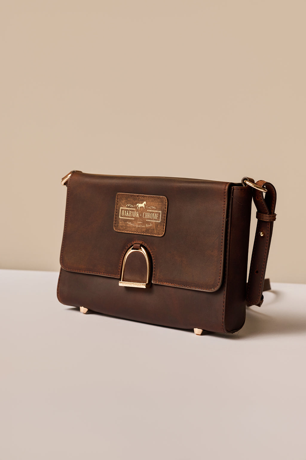 Brown leather bag with a visible brand label on a light gray background