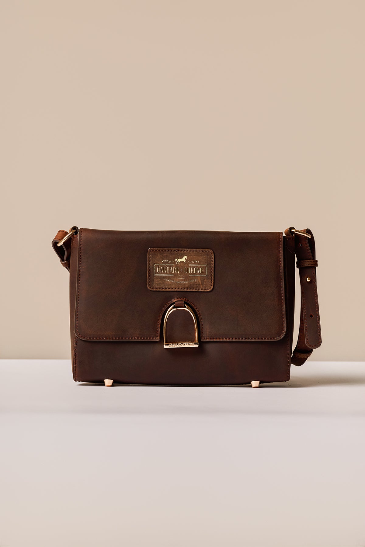 Brown leather bag with a visible brand label on a beige background