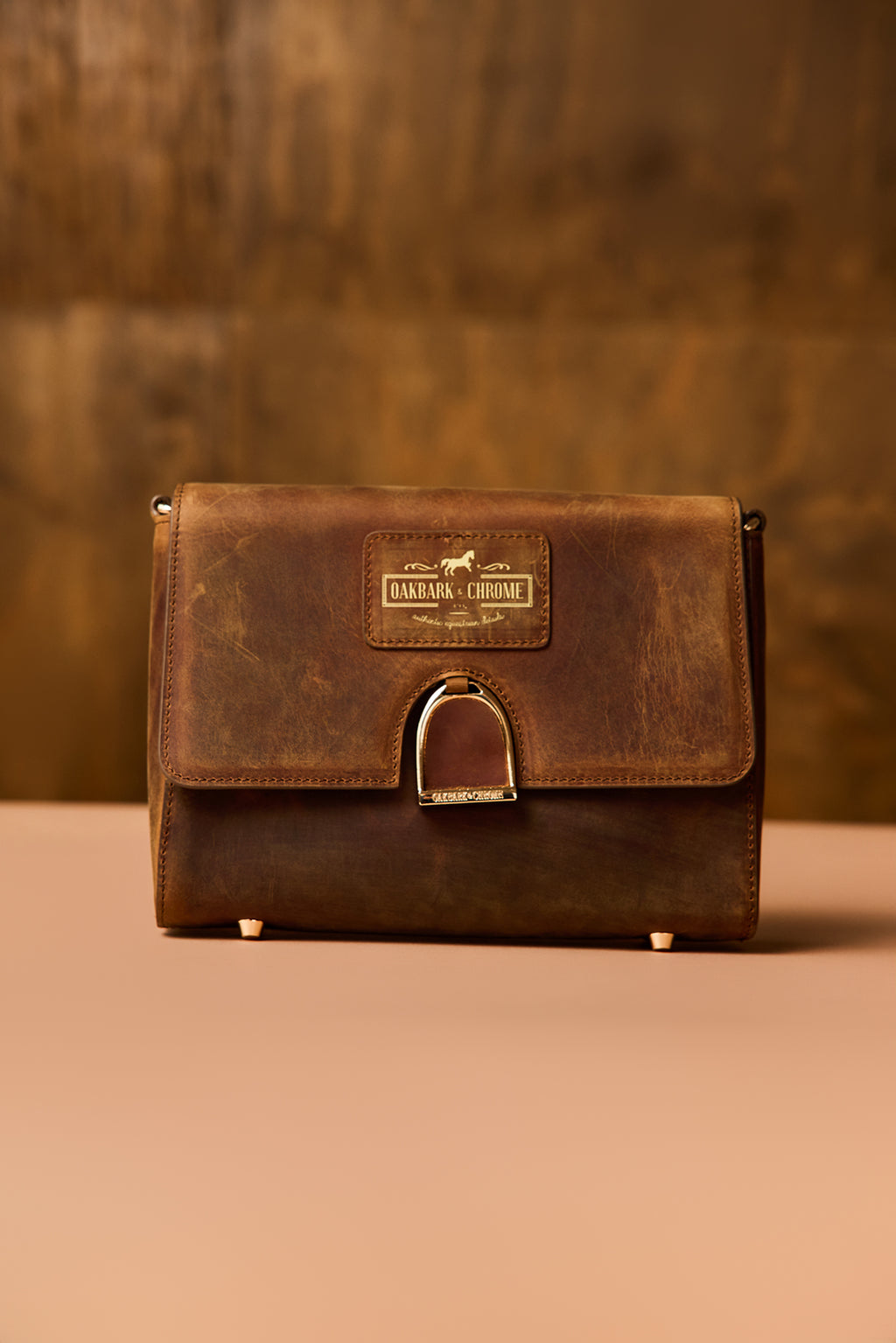 Brown leather bag with a visible brand label on a brown background