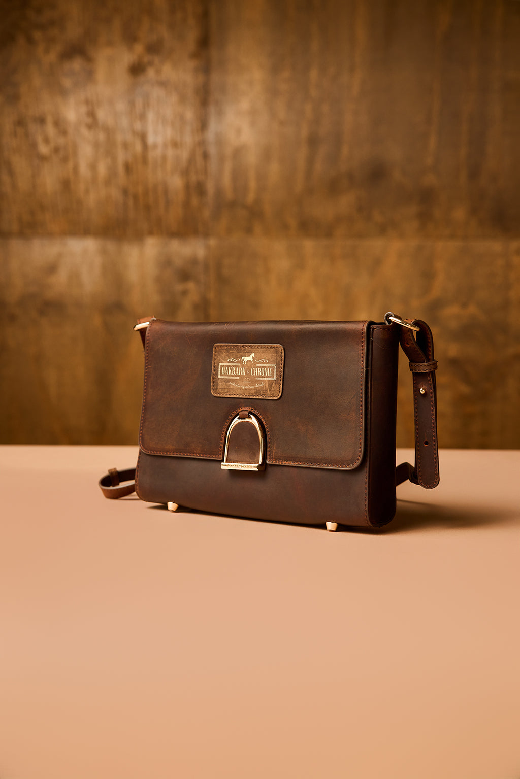 Brown leather bag with a visible brand label on a brown background