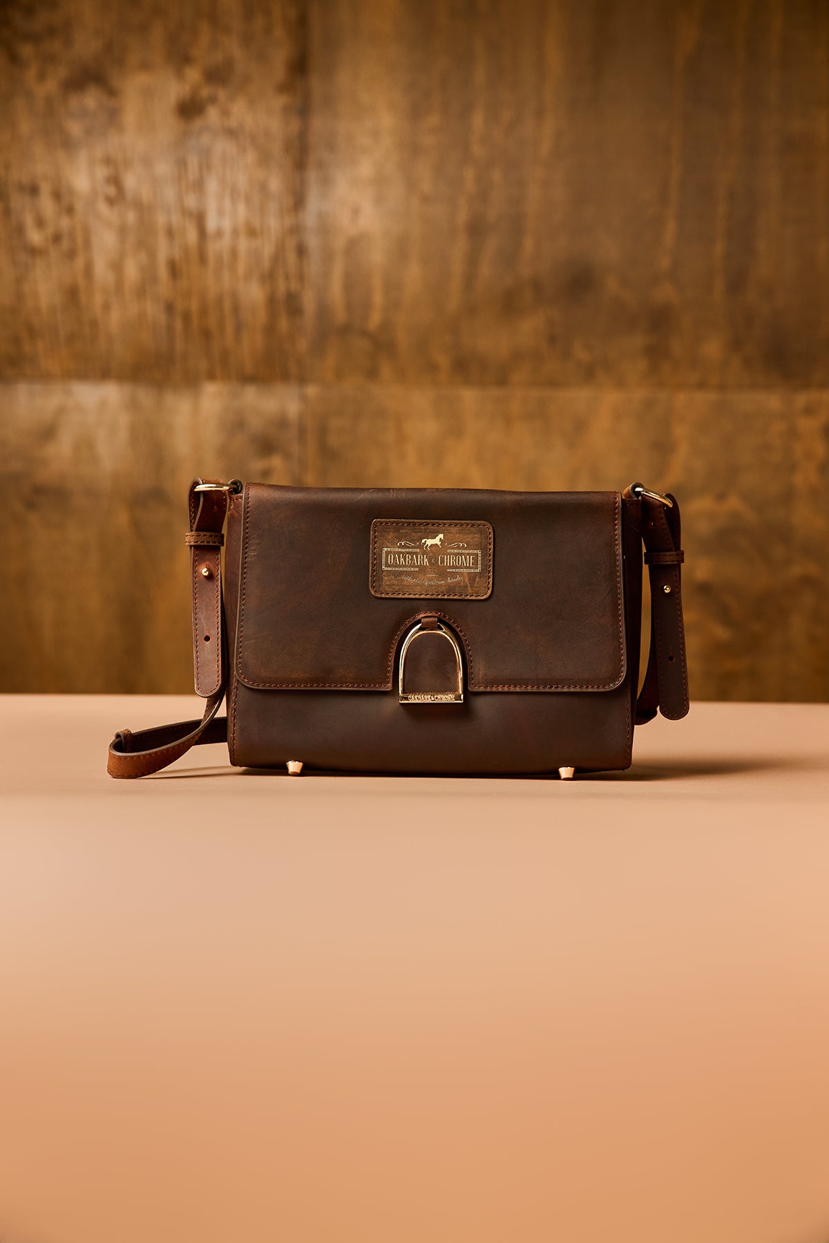 Brown leather bag with a visible brand label on a wooden surface