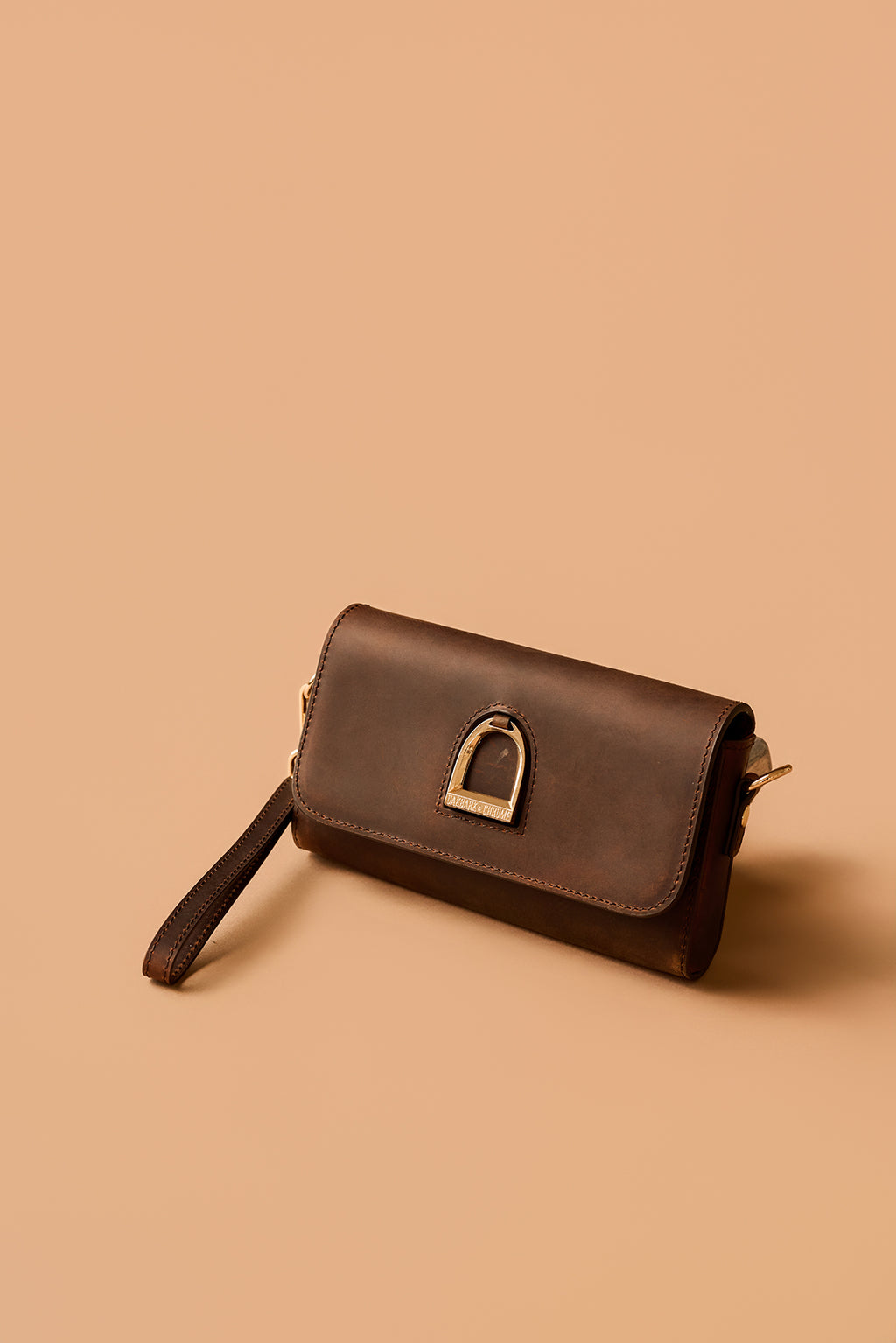 Brown leather clutch bag on a beige background