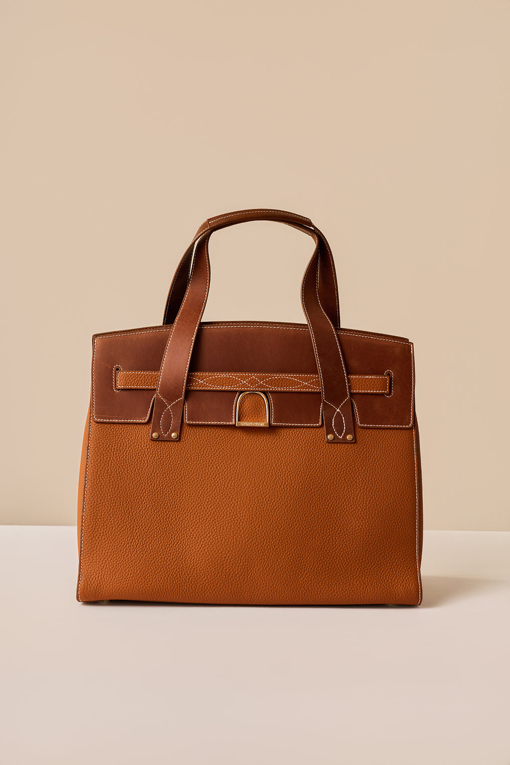 Brown leather handbag on a beige background