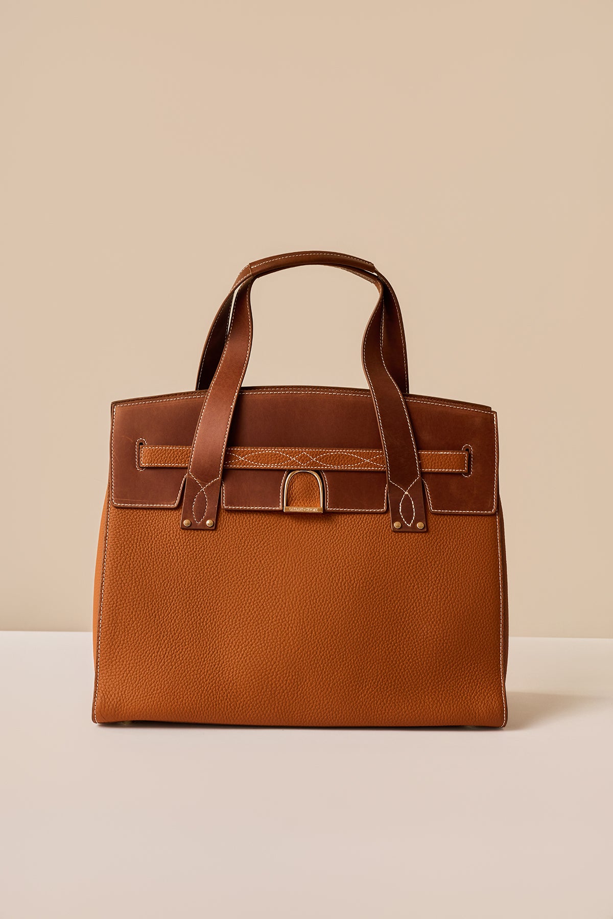 Brown leather handbag on a beige background