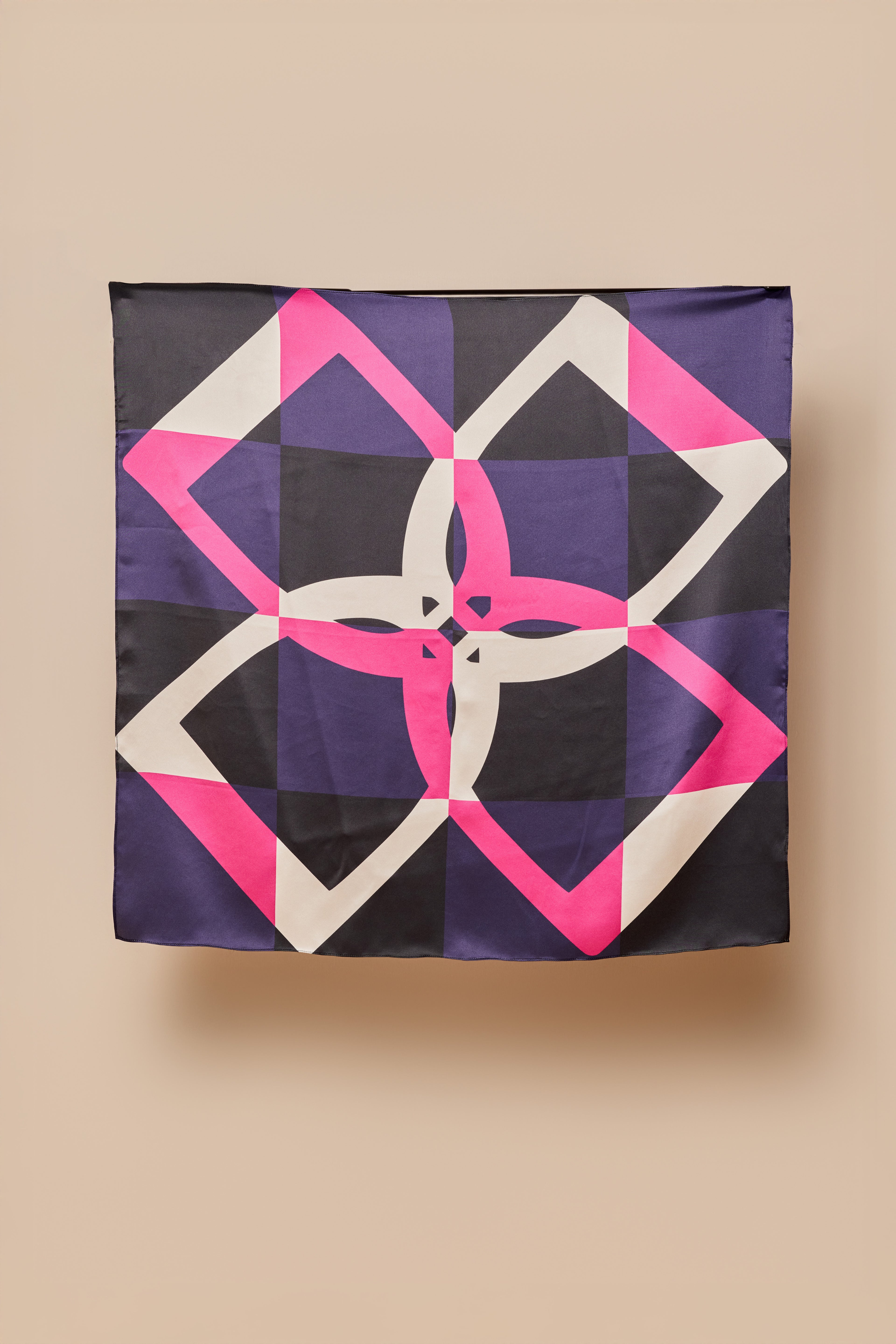 Geometric stirrup patterned silk square on a beige background