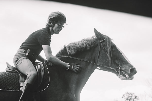 Person riding a horse with a clear sky background
