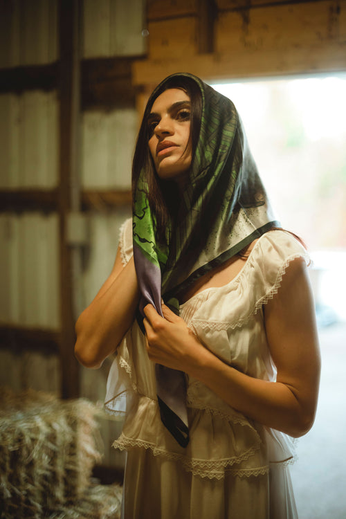 Woman wearing a patterned scarf in a rustic setting