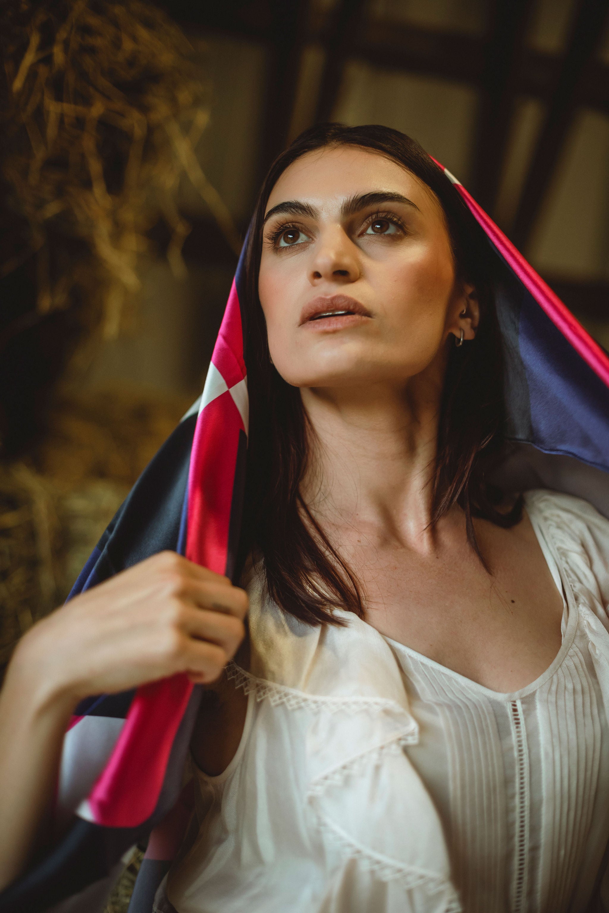 Woman holding a silk scarf with a rustic background