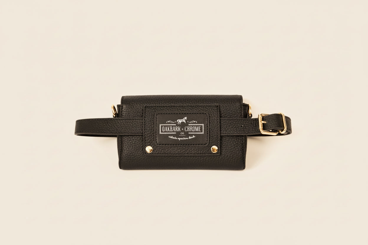 Black leather waist bag with gold accents on a beige background