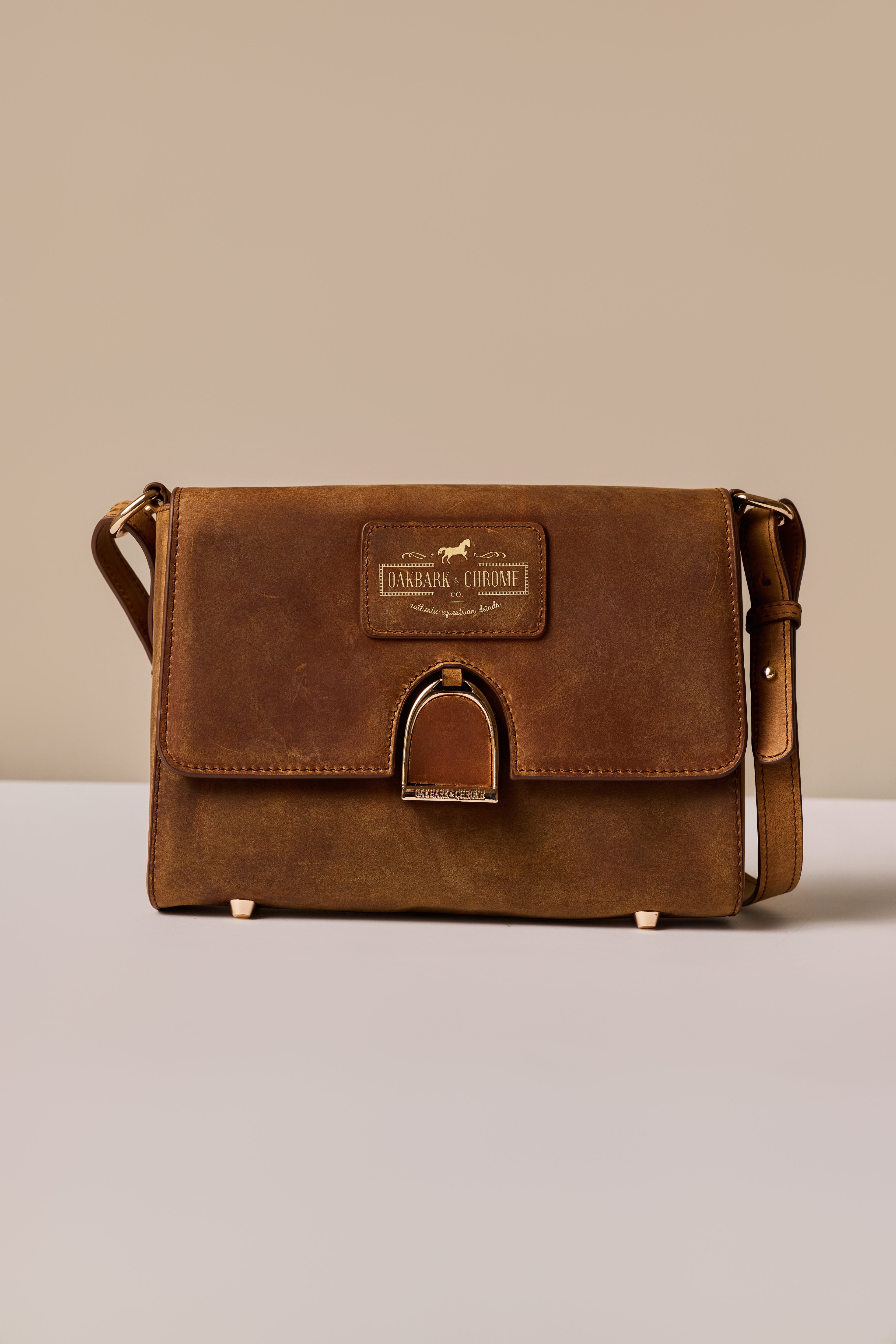 Brown leather bag with a visible brand logo on a neutral background