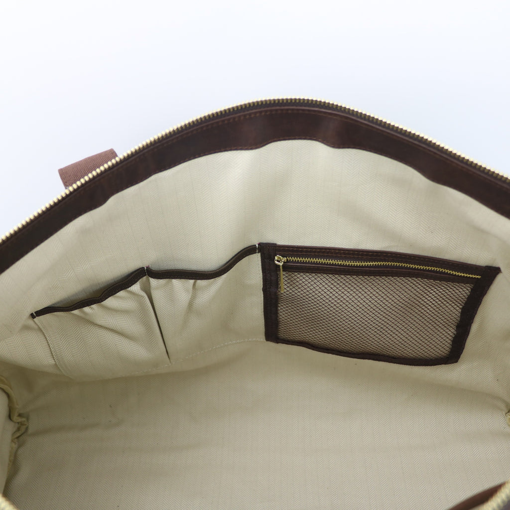 inside of a leather bag, showing a zippered pouch and an open pouch with herringbone lining