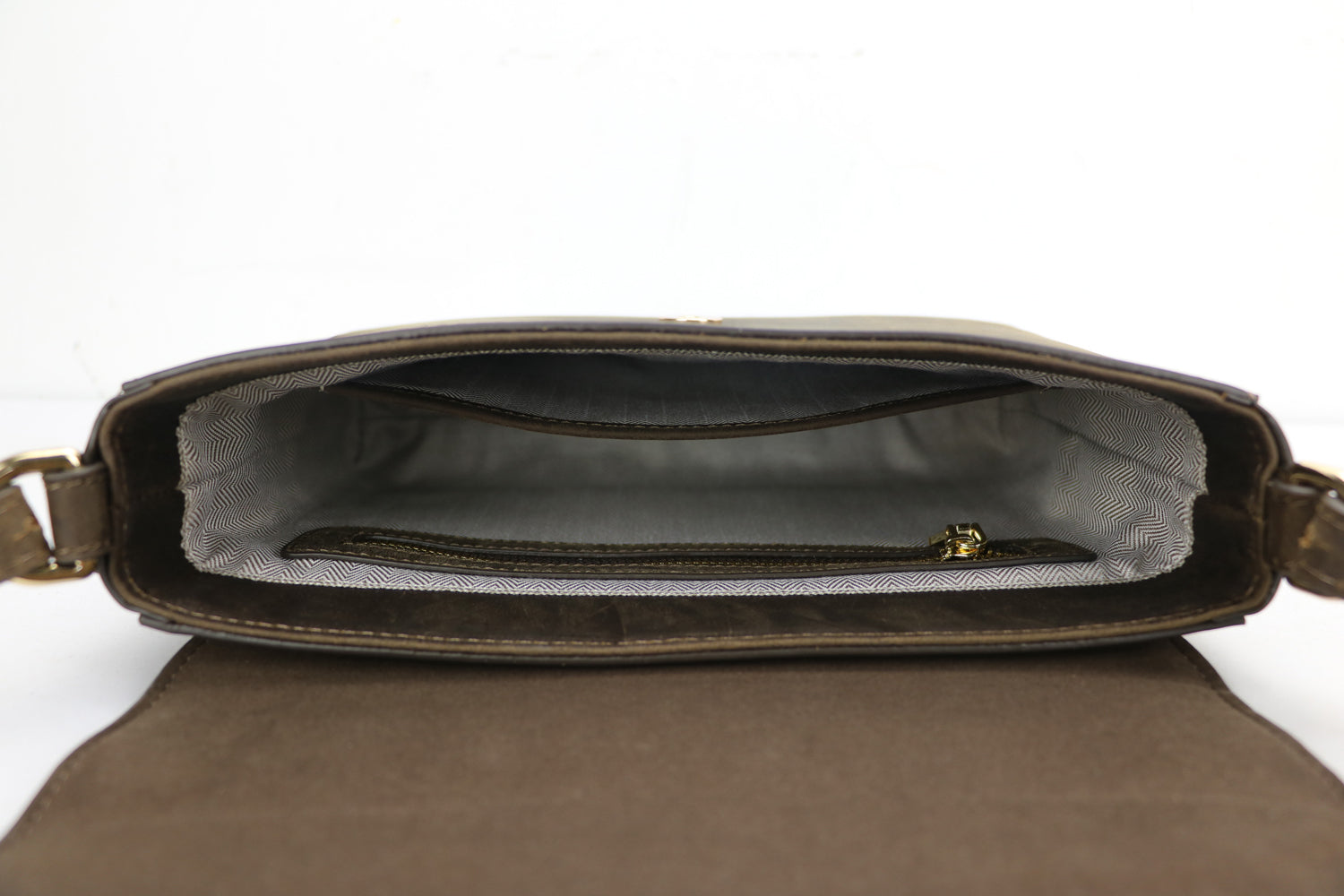 inside of a leather bag, showing a zippered pouch and an open pouch with herringbone lining